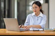 © David - Asian Businesswoman Using laptop computer and working at office with calculator document on desk, doing planning analyzing the financial report, business plan investment, finance analysis concept.