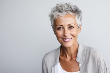 Sticker - Portrait of a happy senior woman smiling at camera against grey background