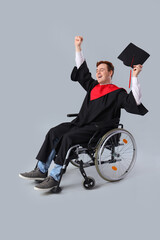 Canvas Print - Happy male graduate in wheelchair on light background