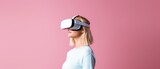 Fototapeta Do przedpokoju - Young woman using virtual reality headset on plain background