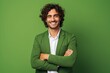 Portrait of a handsome young man with curly hair in a green suit on a green background