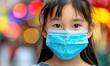 © Aiyawarin - A young girl wearing a blue surgical mask. She is looking at the camera. The image has a somewhat serious and somber mood