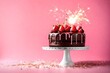 cake with sparkler fire on pink background