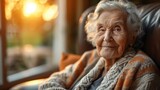 Fototapeta Tęcza - An elderly woman sitting in a chair wearing a cozy sweater