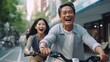 A Young Couple Riding Bicycles and Laughing in the City
