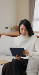 Canvas Print - Vertical view of Woman read on digital tablet computer at home