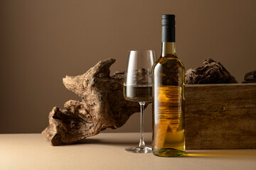 Wall Mural - White wine and old snag on a beige background.