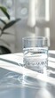 © lelechka - Glass of fresh drink water on table in living room in morning sunny light.