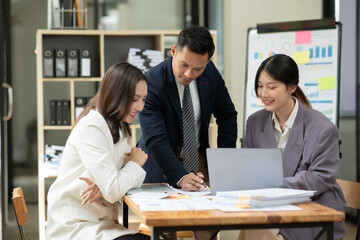 Asian business presents to explain the graph work on the whiteboard. Consulting, discussing, exchanging knowledge.