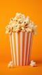 A full popcorn box on a bright orange background, a classic and engaging image for a snack bar menu or a movie-themed party invitation.