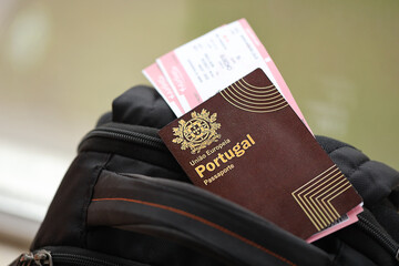 Wall Mural - Red Portugal passport of European Union with airline tickets on touristic backpack close up. Tourism and travel concept