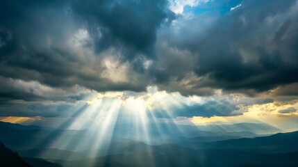 Wall Mural - Rays of light shining through dark clouds It's gonna rain, dramatic sky with cloud, Sky background on sunrise nature composition The beam of light through the dark clouds on the mountains.