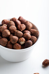 Wall Mural - Hazelnuts in a bowl on a white background. Healthy food.