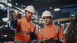 © stockbusters - Two factory specialists controlling work machinery at production close up.