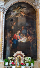 Painting of baby Jesus in the cradle with Mary at his side