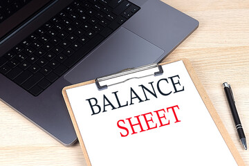 Poster - BALANCE SHEET text written on a paper clipboard on laptop