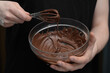 Rozpuszczona czekolada, polewa czekoladowa w miseczce i trzepaczka do mieszania