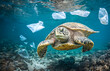 Sea Turtle swimming among plastic waste and litter in the ocean. Trash in the water. Planetary pollution.