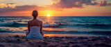 Fototapeta  - jeune femme assise de dos sur la plage en train de regarder le coucher de soleil