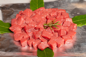 Canvas Print - Beef cubed meat. Butcher products. Chopped raw beef on stone background