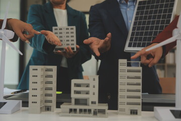 Wall Mural - Close-up at tablet, Engineers pointing at tablet with their hands. To jointly design the use of renewable energy with wind and solar energy. Concept of using renewable energy.