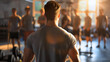 © Nemanja - Rearview of the handsome and fit young man, male fitness instructor or coach standing in the modern gym interior in front of the group of young people who came for a group workout or training indoors