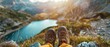 View from lake in the mountains  - Hiking hiker traveler landscape adventure nature sport background panorama - Feet with hiking shoes from a man sitting resting on top of a high hill or rock