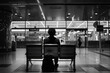A man sits on a bench in a train station
