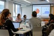 © Thaniya - Eager professionals in a modern conference room laugh and engage, with laptops out, charts projected in the background for review. Colleagues in a dynamic workshop setting, exchanging ideas