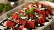 A refreshing salad of watermelon, feta cheese, and mint, drizzled with balsamic glaze