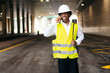 © Koldo_Studio - African architect in reflective gear engaging in a phone conversation.