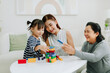 © Marc Tran/Stocksy - Excited children playing game Jenga at home