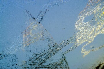 Wall Mural - Eismuster auf Glasscheibe vor Häusern und blauem Himmel bei Sonne, Frost und Eis am Morgen im Winter