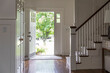 © Raymond Forbes LLC/Stocksy - Contemporary Home open front door in foyer with staircase