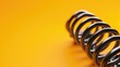 © Tati - Close-up of metal springs against a vibrant yellow background