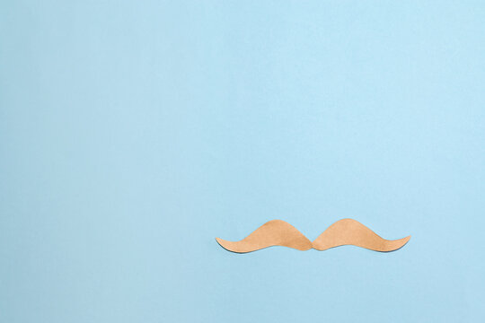  paper mustache on a light blue background. The image conveys a fun and humorous atmosphere. father's day concept. copyspace