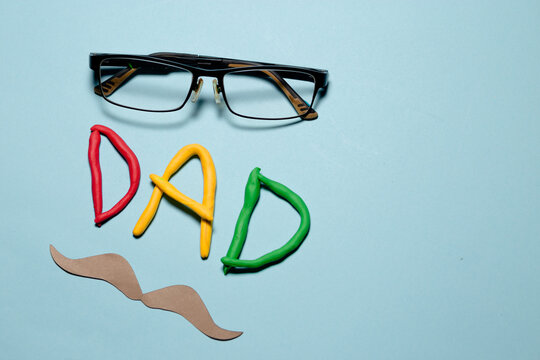 A man's face is made out of various tools and a tie. The word 