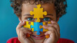 © Mahnoor - world autism awareness day, autism disorder awareness, a boy peeking through colorful puzzle,  child mental health concept, world autism awareness day