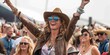 Country music festival with woman wearing cowboy hat in audience listening to band playing country western music