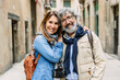 © Xavier Lorenzo - Portrait of senior adult attractive couple smiling at camera at city street. Retired people enjoying vacation.