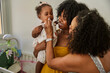 © Edward Córdoba / Andréas Sichel/Stocksy - Baby with mum and granny, all smiling by crib.