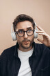 © Pietro Karras/Stocksy - Studio headshot of middle age man in headphones with facial expression