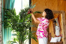 Asian woman decorating green flower with baubles