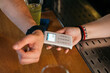 © Pixel Stories/Stocksy - Tap to pay smart watch payment transaction/purchase at bar