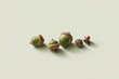 © Yaroslav Danylchenko/Stocksy - Natural green acorns and caps scattered on beige background