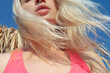 © Sonja Lekovic/Stocksy - Natural lips and blond hair in the wind and blue sky
