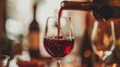 © chanidapa - Red wine being poured in to wine glass with blurred background