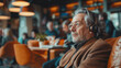 © Jammer Gene - Senior citizen listening to a podcast or radio program using headphones while seated in a coffee shop.