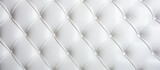 Fototapeta Sypialnia - This close-up shows the detailed texture of a white upholstered mattress, highlighting its softness and comfort. The clean, bright surface invites relaxation and rest.
