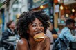 Happy black lady biting fast food in street cafe